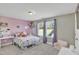 Bright bedroom with a bed, windows, and pink accents for a playful feel at 1016 Leatherstone Ln, Fuquay Varina, NC 27526