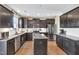 Modern kitchen features dark cabinetry, granite countertops, stainless steel appliances, and an island, perfect for cooking at 1016 Leatherstone Ln, Fuquay Varina, NC 27526