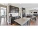 Well-appointed kitchen with dark cabinets, granite countertops, and an island, seamlessly flowing into the living area at 1016 Leatherstone Ln, Fuquay Varina, NC 27526