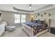 A main bedroom with tray ceiling, carpet and chair near a sunny window at 1016 Leatherstone Ln, Fuquay Varina, NC 27526