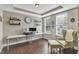 Well-lit home office with modern desk setup, tray ceilings, and comfortable seating, creating an ideal workspace at 1016 Leatherstone Ln, Fuquay Varina, NC 27526