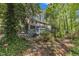 Backyard view of home with screened in porch and large deck nestled amongst mature trees at 108 Maplewood Dr, Knightdale, NC 27545