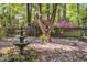 Backyard with fountain, fenced in area, mature trees, and azaleas at 108 Maplewood Dr, Knightdale, NC 27545