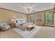 Staged bedroom with a king bed, bench, chair, and natural light from the window at 108 Maplewood Dr, Knightdale, NC 27545