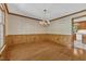 Spacious dining room with hardwood floors, decorative wainscoting, and a chandelier, perfect for entertaining at 108 Maplewood Dr, Knightdale, NC 27545