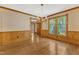 Bright dining room with hardwood floors, large windows, and classic wainscoting, offering a traditional ambiance at 108 Maplewood Dr, Knightdale, NC 27545