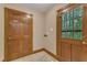 Hallway with ceramic tile, a wooden door with a window, and another wooden door at 108 Maplewood Dr, Knightdale, NC 27545