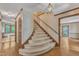 Elegant staircase with plush carpeting, wood trim, and a decorative light fixture enhancing the foyer's appeal at 108 Maplewood Dr, Knightdale, NC 27545