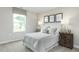 Bright bedroom featuring coordinated decor, a large window, and stylish bedside lamps at 11 Artesa Ct, Fuquay Varina, NC 27526
