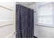 Classic white bathroom features a shower with polka dot curtain and a window at 1106 Sycamore St, Rocky Mount, NC 27801