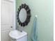 Cozy half bath with green walls, mirror, vanity, and decorative details at 1106 Sycamore St, Rocky Mount, NC 27801