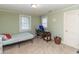 Bedroom with pale green walls, single bed, desk, and two windows allowing natural light at 1106 Sycamore St, Rocky Mount, NC 27801