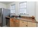 Well-lit kitchen featuring stainless steel refrigerator and a sink with double windows at 1106 Sycamore St, Rocky Mount, NC 27801
