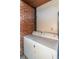 Functional laundry room features a white washer and dryer setup next to a brick wall at 1106 Sycamore St, Rocky Mount, NC 27801