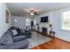 Comfortable living room with a fireplace, large sofa, hardwood floors, and natural light at 1106 Sycamore St, Rocky Mount, NC 27801