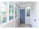 Enclosed sunroom features multiple windows, natural light, and a gray door at 1106 Sycamore St, Rocky Mount, NC 27801