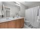 Bathroom with double sinks, wood cabinets, and a shower-tub combination at 112 Natchez Ct, Cary, NC 27519