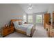 Comfortable bedroom with vaulted ceiling, wood furniture, and natural light at 112 Natchez Ct, Cary, NC 27519