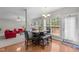 Bright dining area featuring a table with leather chairs and bench, and a view into the living room with a fireplace at 112 Natchez Ct, Cary, NC 27519