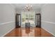 Elegant dining room with hardwood floors, chandelier, decorative cabinets, and a large window at 112 Natchez Ct, Cary, NC 27519