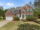 Beautiful two-story brick home with green shutters, a two-car garage, and a well-manicured lawn at 112 Natchez Ct, Cary, NC 27519