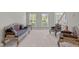 Elegant formal living room with stylish furniture, large windows, and a grand staircase at 112 Natchez Ct, Cary, NC 27519