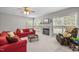 Bright living room featuring a fireplace, large windows, and comfortable red sofas at 112 Natchez Ct, Cary, NC 27519