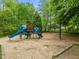 Community playground featuring a slide, swings, and climbing structure surrounded by wood chips at 112 Natchez Ct, Cary, NC 27519