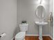 Clean powder room with pedestal sink, oval mirror, and hardwood floors at 112 Natchez Ct, Cary, NC 27519