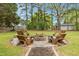 A fire pit sitting area with wooden chairs in a backyard landscape provides an inviting outdoor space at 119 Johnson St, Broadway, NC 27505