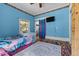 Eclectic bedroom with blue walls, wood laminate floors, and bold patterns at 119 Johnson St, Broadway, NC 27505