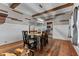 Bright dining room featuring wood floors, high ceilings and rustic wood beams looking into the kitchen at 119 Johnson St, Broadway, NC 27505