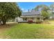 Charming two-story white home with a welcoming wraparound porch, vibrant landscaping, and an American flag at 119 Johnson St, Broadway, NC 27505