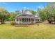 Charming two-story white home with a welcoming wraparound porch, vibrant landscaping, and an American flag at 119 Johnson St, Broadway, NC 27505