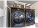 Modern black washing machine and dryer in laundry area with storage space and natural light at 119 Johnson St, Broadway, NC 27505