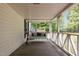 Covered porch with an inviting swing, decorative pillows, and a charming outdoor space at 119 Johnson St, Broadway, NC 27505