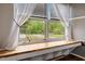 Cozy window seat with a view of the surrounding landscape and sheer curtains at 119 Johnson St, Broadway, NC 27505