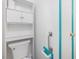Cozy bathroom featuring white cabinets, toilet, and turquoise accents at 1204 Hydrangea Ct, Hillsborough, NC 27278