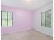 Bedroom with large windows, light carpet, and painted pink accent wall at 1204 Hydrangea Ct, Hillsborough, NC 27278