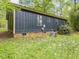 Exterior side view of home showing siding, brick foundation, and backyard at 1204 Hydrangea Ct, Hillsborough, NC 27278