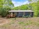 Charming single-story home with a wooden porch, set amidst a backdrop of trees at 1204 Hydrangea Ct, Hillsborough, NC 27278