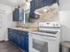 Bright kitchen with blue cabinets, tile backsplash, and stainless steel appliances at 1204 Hydrangea Ct, Hillsborough, NC 27278