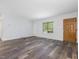 Open living room with modern vinyl floors, a front door, and a window view at 1204 Hydrangea Ct, Hillsborough, NC 27278