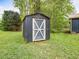 Backyard storage shed with white trim door in a well-maintained outdoor setting at 1204 Hydrangea Ct, Hillsborough, NC 27278
