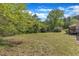 Expansive backyard featuring a lush lawn and mature trees, creating a serene outdoor space at 1213 Walnut St, Cary, NC 27511