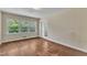 An airy bedroom with hardwood floors has natural light from a large window at 1213 Walnut St, Cary, NC 27511