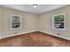 A bright bedroom features hardwood floors and natural light from two windows at 1213 Walnut St, Cary, NC 27511