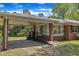Exterior shot of the brick home with carport, ramp, and large window at 1213 Walnut St, Cary, NC 27511