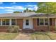 Close up of the brick facade, windows, and front door with steps to the house at 1213 Walnut St, Cary, NC 27511