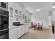White kitchen with dark stovetop and oven and a dining area at 1213 Walnut St, Cary, NC 27511